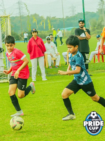 Two players racing for a loose ball, demonstrating the fast-paced nature of our youth football games.