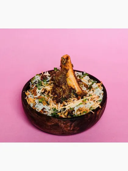 A clean and modern e-commerce photo of mutton biryani against a solid pink background. This style is designed for food delivery apps like Swiggy and Zomato, making the dish look appealing on any screen.