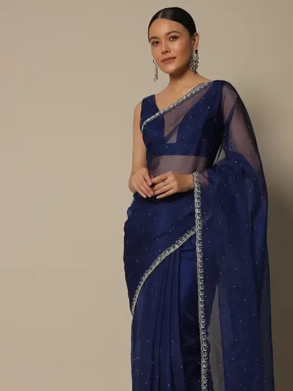 A classic look with a sheer navy blue saree. The clean makeup and simple, pulled-back hairstyle add to the elegance, making it a perfect choice for an evening event.