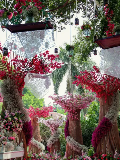 A wide view of the floral wonderland, showcasing the hanging lanterns, sculptural trees, and the sheer volume of flowers used to create this immersive experience.