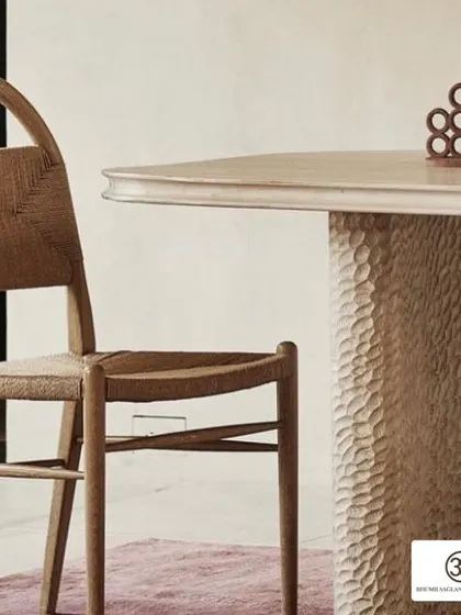This bespoke dining table features a beautifully textured base, adding a rustic yet sophisticated touch. It's paired with a classic woven chair, showing how I love to mix different materials and styles.
