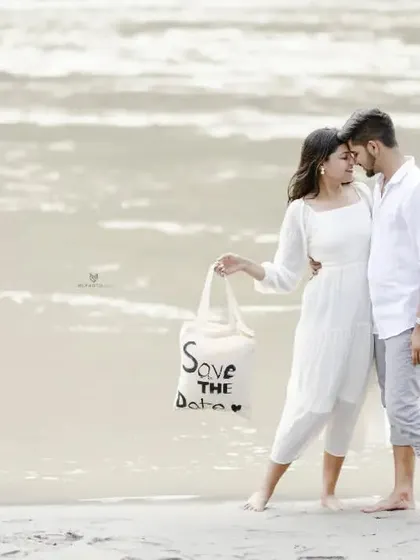A sweet "Save the Date" photo on the beach, with the couple holding a custom tote bag. It's a creative and personal way to share their news.