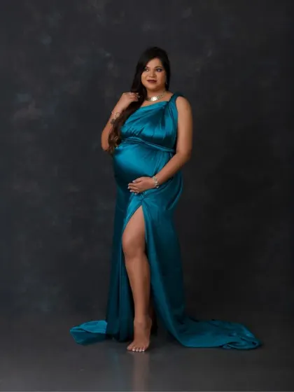 A confident and powerful stance. The rich teal fabric and the simple dark background put all the focus on the beautiful mother-to-be.