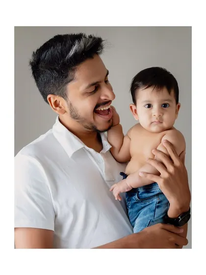 A father and son share a happy moment during a studio milestone session.