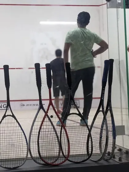 A view into the court with rackets lined up, ready for action. We provide all necessary gear for trial sessions, making it easy for anyone to start.