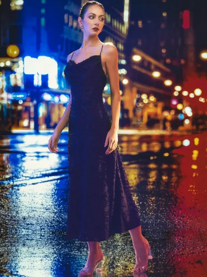 This nighttime city street, with its vibrant neon lights, is a projected backdrop. The lighting on the model is designed to look like it's coming from the neon signs, creating a cohesive and dynamic urban scene.
