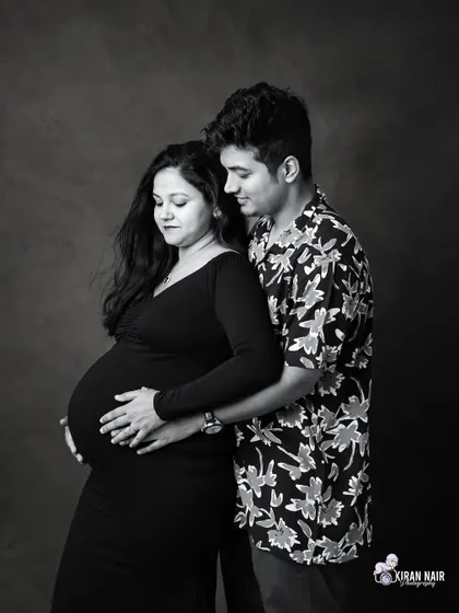 A classic black and white couple's portrait against a dark studio backdrop. This style creates a dramatic and intimate feel, focusing on the couple's expressions.