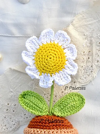 A close-up of our sweet crochet daisy pot. The details in the petals and the vibrant yellow center make it a truly special piece.