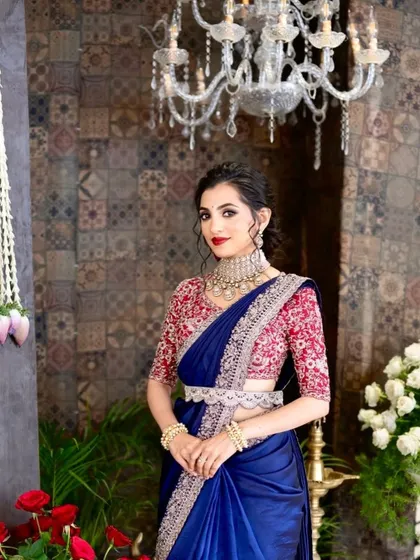 A full-length view of this gorgeous reception look, showing the elegant saree, contrasting blouse, and the confident poise of the bride.