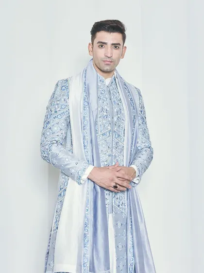 A full-length studio shot of the powder blue sherwani, demonstrating its flawless fit and regal silhouette. The coordinated accessories complete this bespoke groom's outfit.