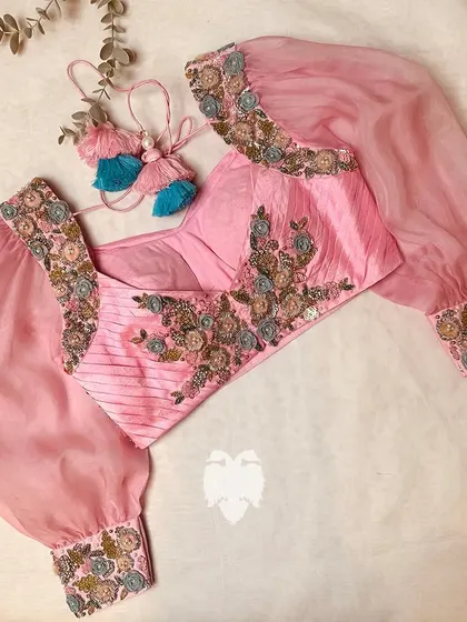 A different angle of the light pink blouse, highlighting the sheer volume of the sleeves.