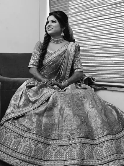 A timeless black and white portrait of a bride seated, her beautiful smile lighting up the frame.