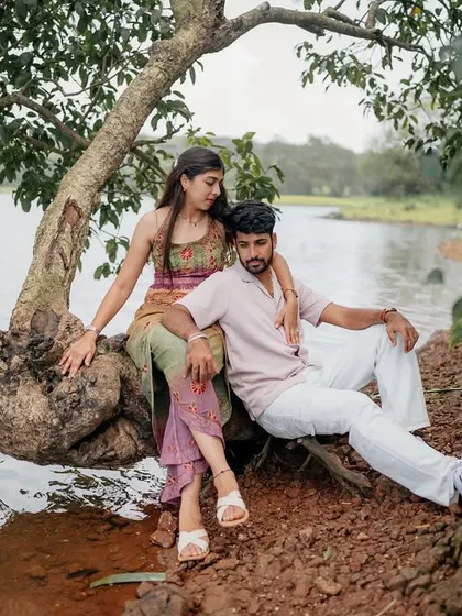 Relaxing together by the lakeside. The unique shape of the tree provides a natural frame for this serene couple portrait.