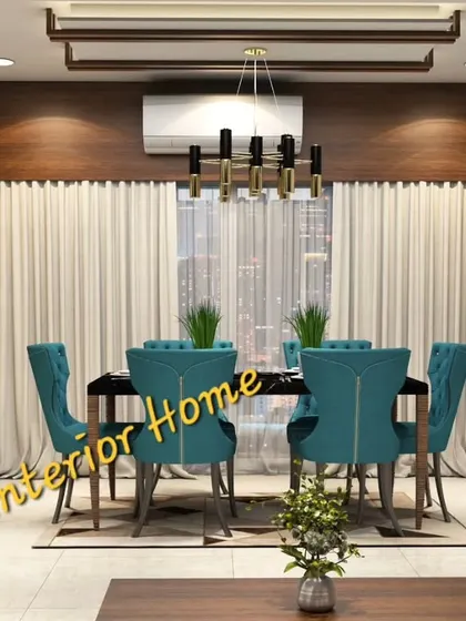 An elegant dining space designed for a family in Mumbai. It features plush teal dining chairs, a dark wood table, and a custom crockery unit with a mix of open and closed storage, all set against a backdrop of sheer curtains.