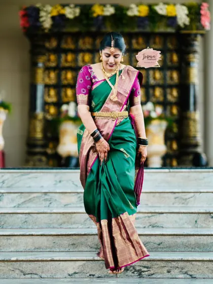 A candid moment of the bride walking down the stairs. Her makeup and styling are designed to be flawless and hold up beautifully throughout the long hours of wedding rituals.