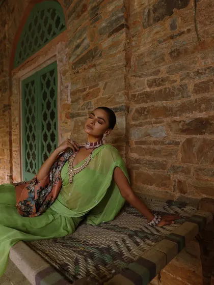 A serene yet opulent look from a heritage jewellery campaign. I styled a lime green saree with a floral cape and a stunning ruby choker and necklace set, creating a beautiful contrast against the rustic stone architecture.
