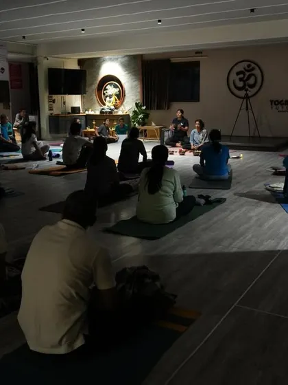 The serene setting of our fusion workshop, combining aerial yoga with sound healing meditation. The low light and focused sound create a perfect environment for deep relaxation and inner peace.