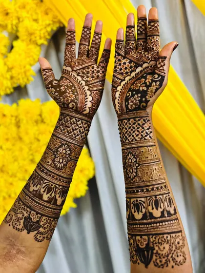 A stunning bridal design set against a festive yellow background. The artwork is dense and detailed, covering the hands and arms in traditional patterns that are perfect for a wedding celebration.