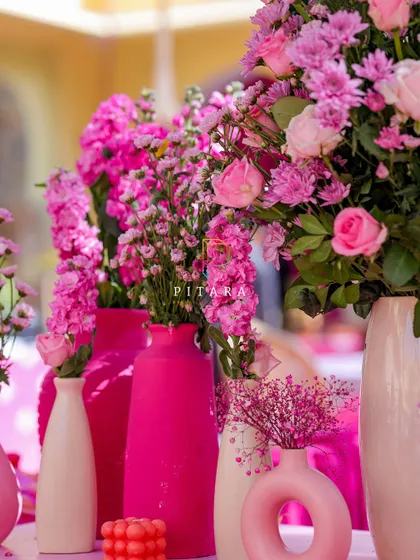 A close-up on the variety of modern vases we used, from textured ceramic to sleek, donut-shaped designs. The mix of shapes and shades of pink adds visual interest and sophistication.