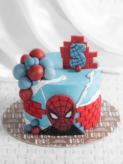 Swing into action with this amazing Spiderman-themed cake for a 5th birthday. It features Spidey's mask, a brick wall design, and web details.