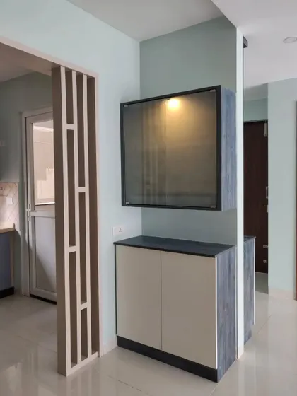 A custom crockery unit designed as part of the kitchen partition, featuring a mix of rustic-patterned laminate and a fluted glass shutter.