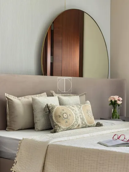 For this guest bedroom, we designed a plush wingback bed and placed a large backlit mirror behind it for better Vastu. The fluted panels and French moulding add a touch of timeless charm.