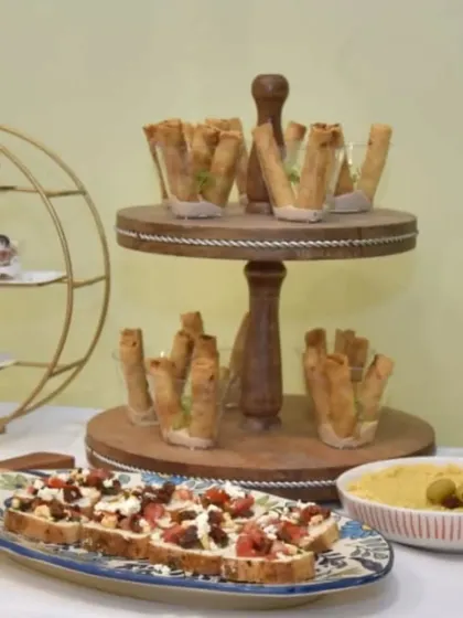 A display of our popular appetizers, including our signature Truffle Cigar Rolls and a platter of fresh bruschetta with feta and tomatoes.
