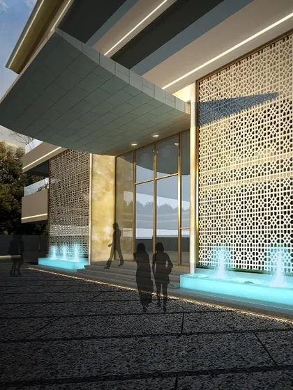 The main entrance of this building is defined by a transition of materiality, sound, and scale. The intricate screen, illuminated water features, and grand canopy create a psychological threshold, preparing you for the distinct environment within.
