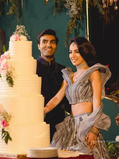 A joyful cake cutting moment at an elegant outdoor reception. The towering cake, adorned with fresh flowers, becomes a beautiful centerpiece for the celebration.