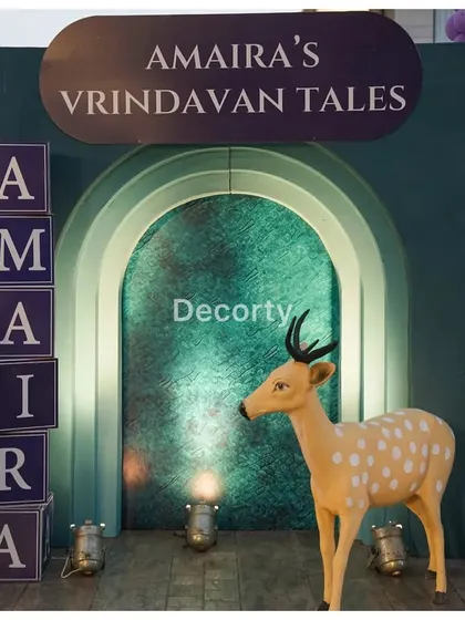 A close-up of the personalized entrance for 'Amaira's Vrindavan Tales', featuring custom name blocks and a deer prop.