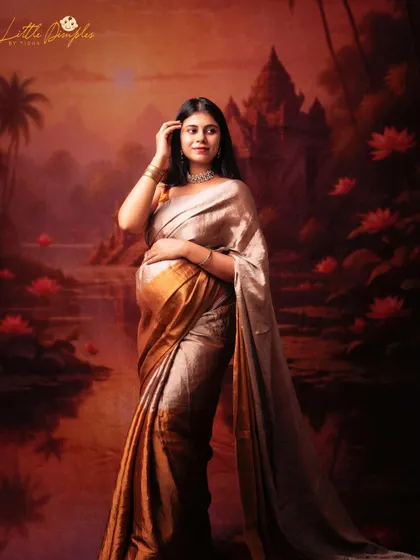 The warm, glowing tones of this fine art portrait are just magical. The mom-to-be looks like a goddess in her golden saree against the painted temple backdrop.
