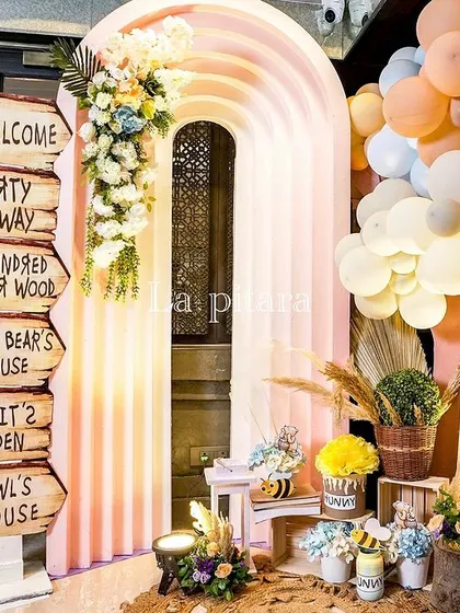 A whimsical entrance to the Hundred Acre Wood, with a signpost directing guests to Pooh Bear's House and Rabbit's Garden.