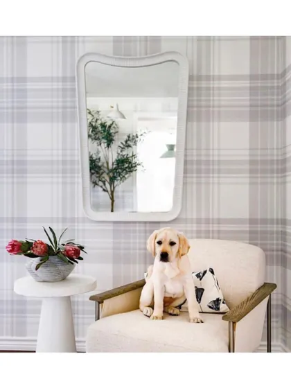 A classic plaid wallpaper creates a cozy and preppy atmosphere. In this space, it provides a timeless backdrop that feels both sophisticated and welcoming, proving that traditional patterns can feel fresh and modern.