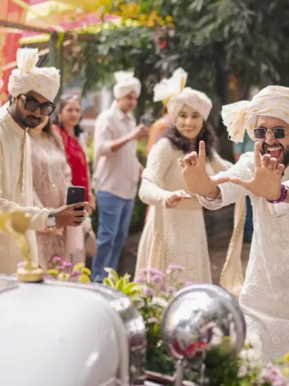 The Baraat is the heartbeat of the celebration. Here, the groom's friends dance with joy next to the beautifully decorated vintage wedding car.