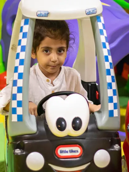 Beep beep! This little one is taking a ride in our cute and friendly-faced toy car, a favorite among our youngest visitors.