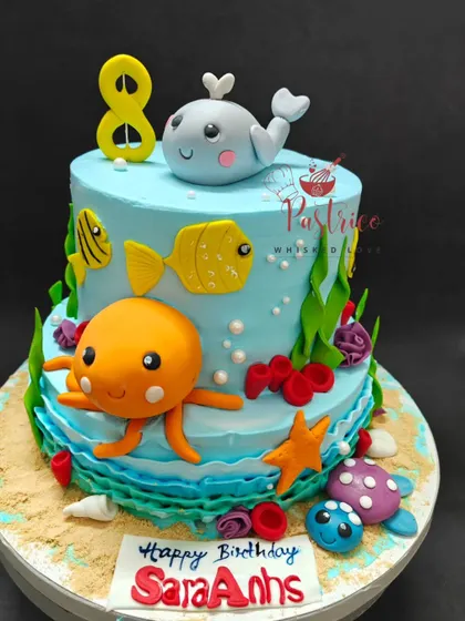 An underwater adventure awaits with this two-tiered aqua-themed cake. It's decorated with cute, edible sea creatures like an octopus, whale, and fish.