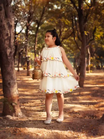 A magical moment in the woods, as this little girl holds a lantern that seems to be sprinkling fairy dust.