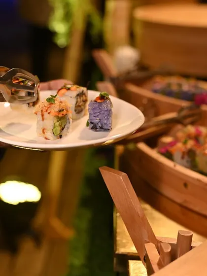 A guest selects their favourite rolls from our live sushi station, showcasing the interactive and personalized nature of the experience.