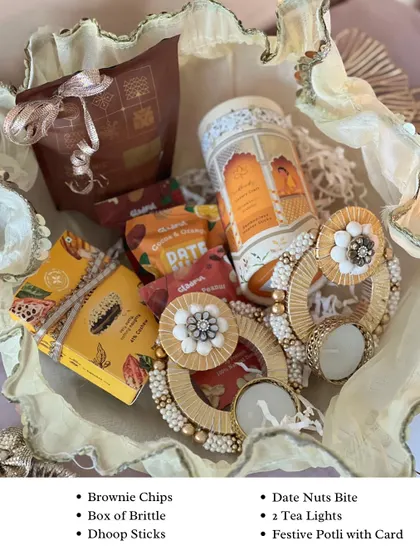Here's what's inside the Diwali Potli Hamper. It includes brownie chips, a box of brittle, dhoop sticks, date nut bites, and two festive tea lights.