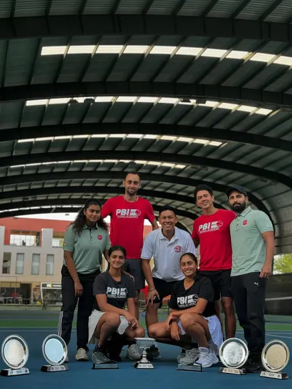 A full team celebration. Our coaches and players come together to honor the remarkable achievements of our women's doubles team, showcasing the strong, supportive family we have built at PBI.