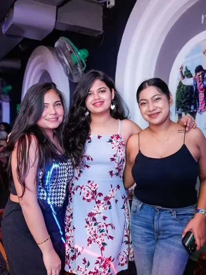 Friends posing for a picture against a cool, artistic backdrop in the club. The entire venue is part of the experience.