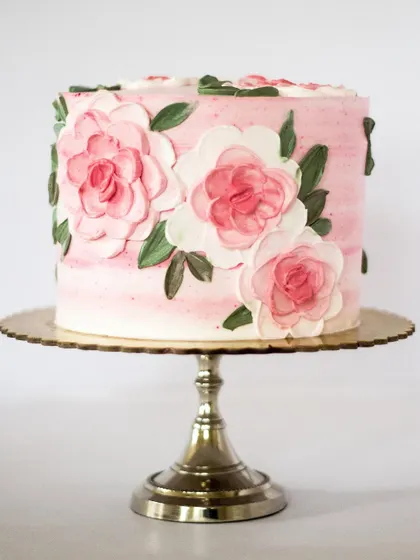 Pretty in pink! This cake features large, hand-painted roses in varying shades of pink on a soft pink ombre background. It's a classic and popular design that's perfect for birthdays, bridal showers, or any feminine celebration.