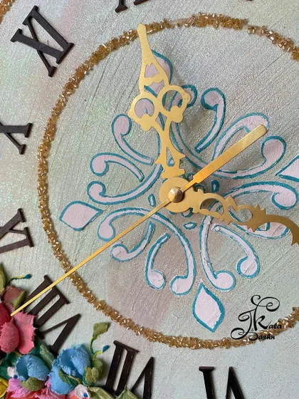 A macro view of the clock's center, with its delicate stencil pattern and golden hands.