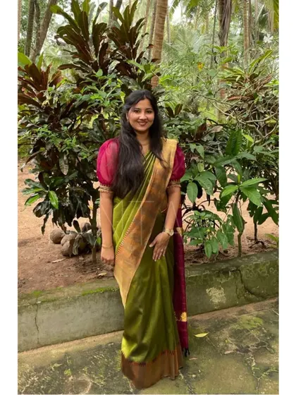 A client wearing a lovely olive green saree with a custom blouse featuring sheer puff sleeves and embroidered cuffs. This was part of a mother-daughter coordinated set.