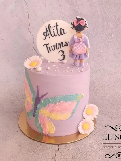 A simple and sweet cake for Alita's 3rd birthday. This 1 kg Ferrero Crunch cake has a lovely lavender buttercream finish, a hand-painted butterfly, and a cute fondant girl figurine.