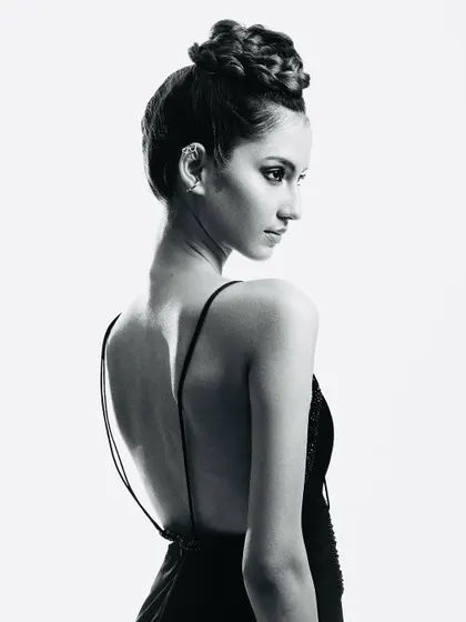 A timeless black and white portrait. The focus is on the elegant, braided updo and the clean lines of the profile, showcasing a classic beauty that transcends color.