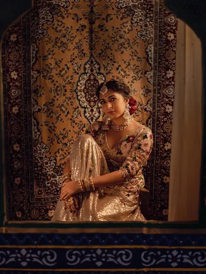 A wider shot of Leona Lishoy, framed by a traditional window. The set design and styling work together to create a rich, cinematic image reminiscent of a vintage painting.