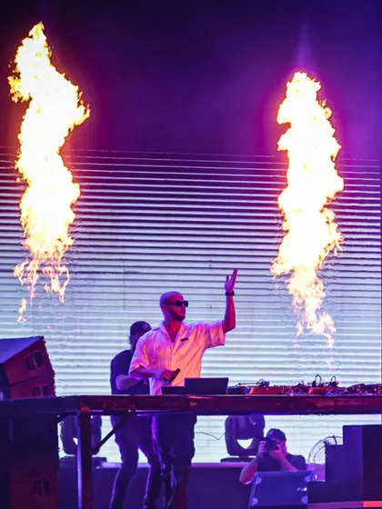 Twin pillars of fire frame DJ Snake in this epic shot, highlighting the intense energy of his shows.