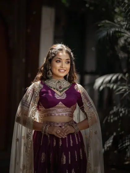 A happy and confident bridal portrait. The bride's vibrant purple lehenga and the bright, natural light perfectly capture her joyful spirit.