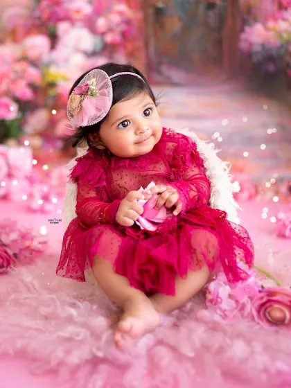 A sweet moment of her holding a pink flower, looking like a little pixie in her garden.